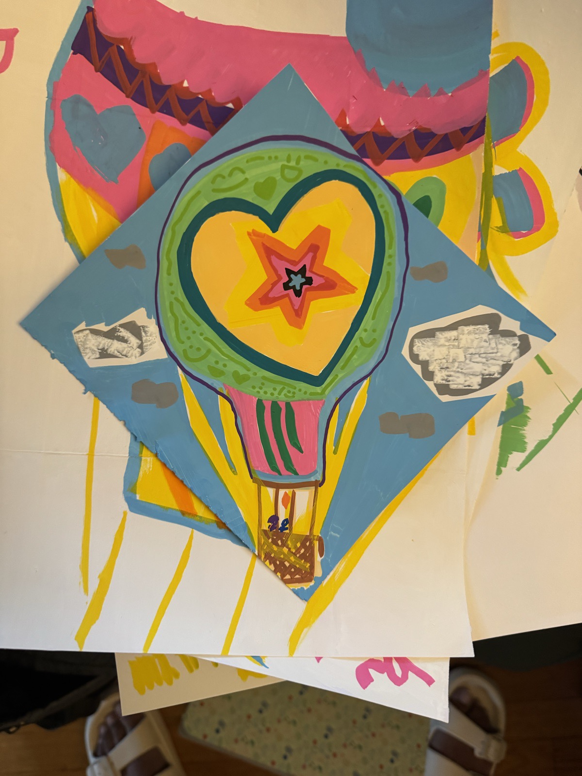 Hot-air balloon collage: a heart and a star inside the balloon, on blue diamond-cut paper with grayscale cutouts